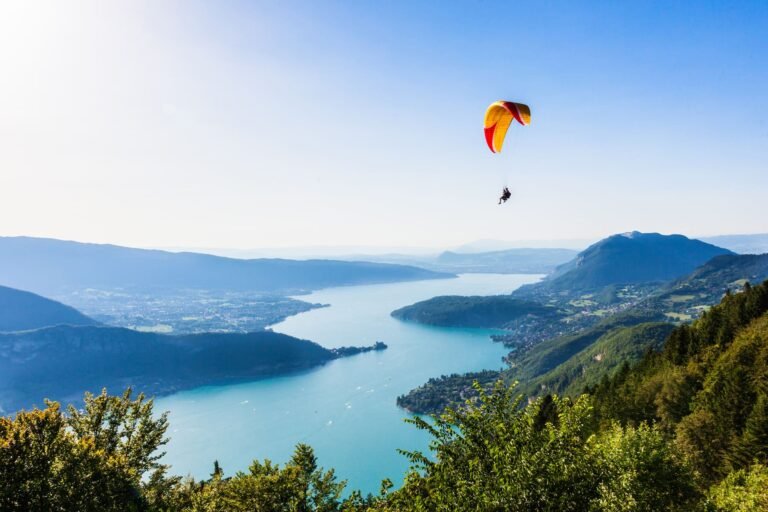 Vue sur le lac d'Annecy avec un parapente dans les airs depuis le col de la Forclaz